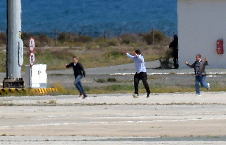 The remaining passengers on the hijacked EgyptAir Airbus A-320, which was diverted to Cyprus, run on the tarmac after leaving the plane as the hijacker surrendered to security forces after a six-hour standoff at Larnaca airport’s largely disused old terminal on March 29, 2016.