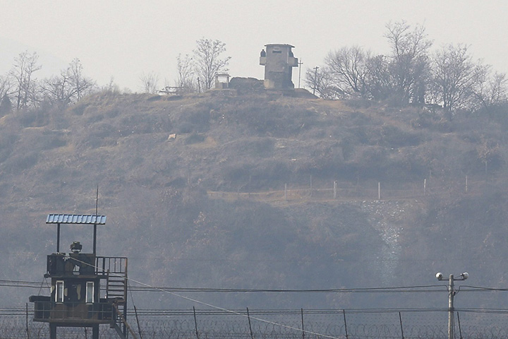 Two North Korean soldiers stand guards on their sentry post (background) and South Korean sentry post (front) stand on opposite sides of the inter-Korean border in the border city of Paju, in Gyeonggi-do, South Korea, on March 3, 2016.