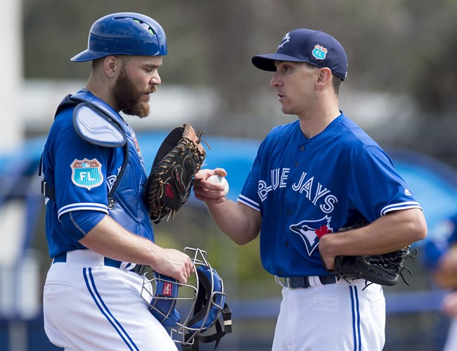 Toronto Blue Jays pitcher Pat Venditte and catcher Russell Martin chat on the mound during an intersquad game at spring training in Dunedin, Fla. on Monday, February 29, 2016. THE CANADIAN PRESS/Frank Gunn.