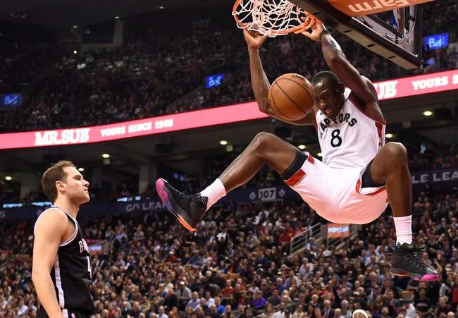 Toronto Raptors' Bismarck Biyombo (8)dunks as Brooklyn Nets' Bojan Bogdanovic (44) looks on during second half NBA action in Toronto on Tuesday March 8, 2016. THE CANADIAN PRESS/Frank Gunn.
