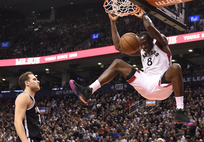 Toronto Raptors' Bismarck Biyombo (8)dunks as Brooklyn Nets' Bojan Bogdanovic (44) looks on during second half NBA action in Toronto on Tuesday March 8, 2016. THE CANADIAN PRESS/Frank Gunn.