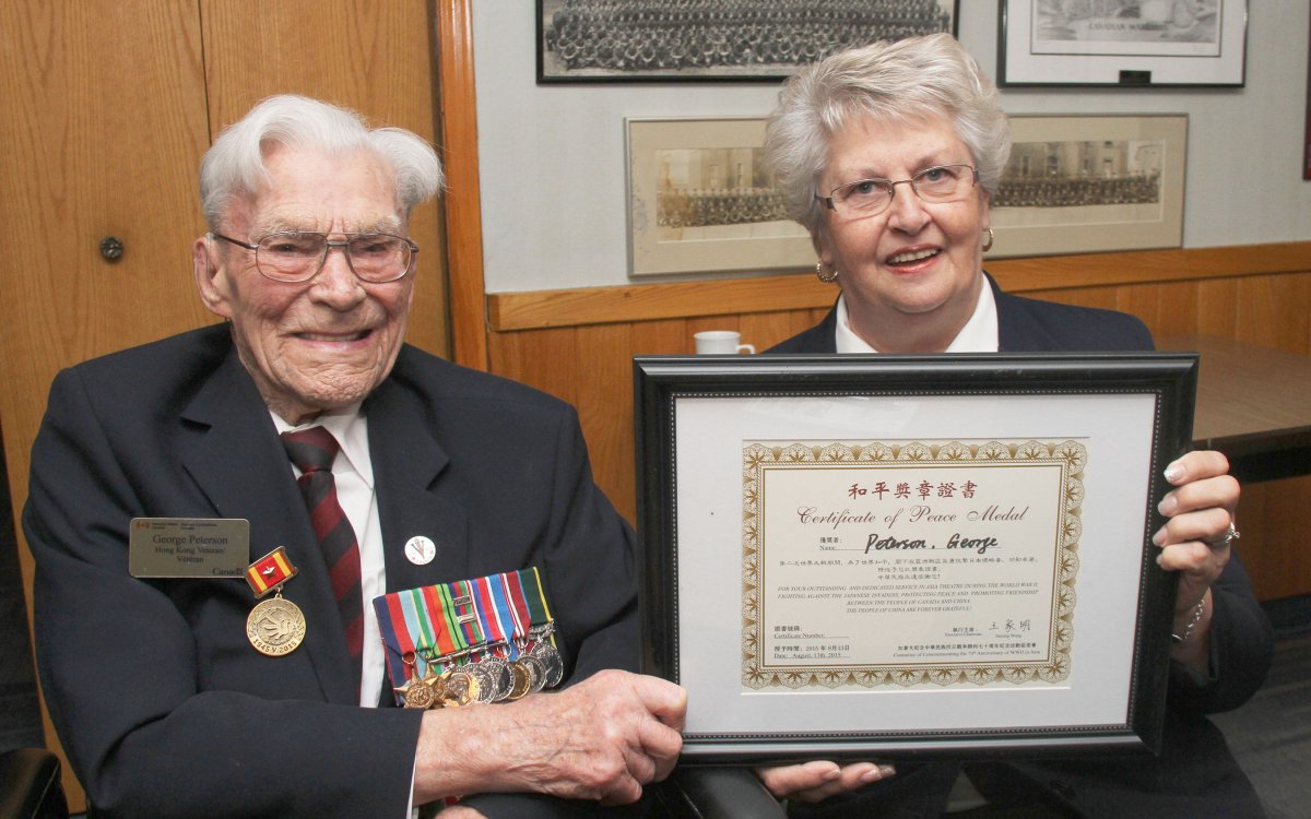 George Peterson receives the Chinese Peace Certificate from Carol Hadley, the Secretary of the Hong Kong Veterans Association.