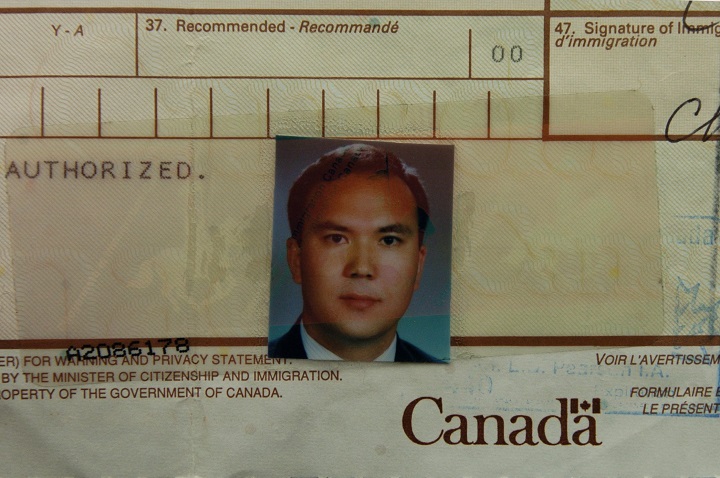A demonstrator holds an immigration document bearing the photograph Huseyin Celil of during a protest for his release in front of the Chinese Consulate in Toronto, Ont. on November 2006.