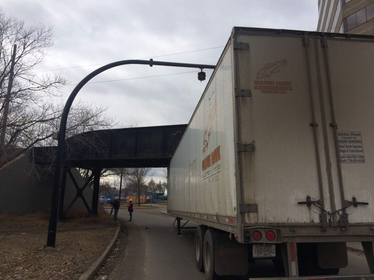 Semi wedged beneath a city overpass.
