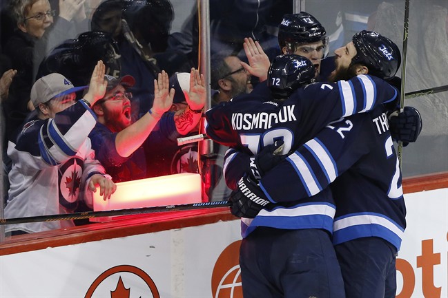 Winnipeg Jets' Scott Kosmachuk (72), Adam Lowry (17) and Chris Thorburn (22) celebrate Lowry's game-winning goal against the Colorado Avalanche during third period NHL action in Winnipeg on Saturday, March 12, 2016.