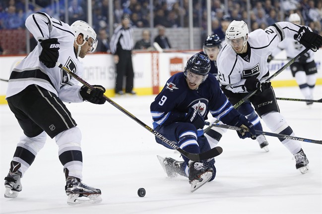Winnipeg Jets' Andrew Copp (9) attempts to bust through Los Angeles Kings' Alec Martinez (27) and Nick Shore (21) during second period NHL action in Winnipeg on Thursday, March 24, 2016. 