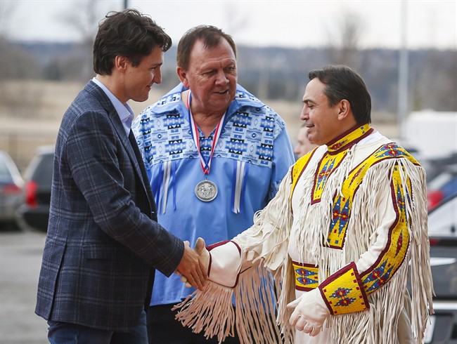 Prime Minister Justin Trudeau, left, is greeted by Chief Roy Whitney, centre, and National Chief Perry Bellegarde as he arrives on the Tsuut'ina First Nation near Calgary, Alta., Friday, March 4, 2016. 