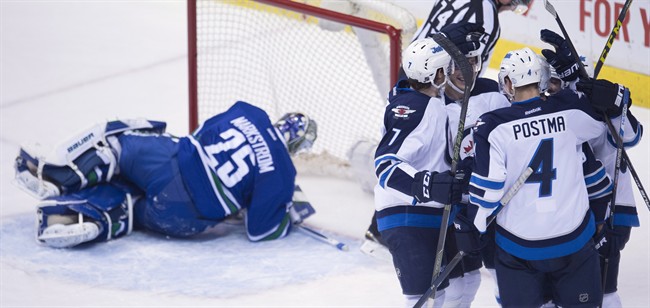 The Winnipeg Jets celebrate teammate Marko Dano's goal past Vancouver Canucks goalie Jacob Markstrom (25) during third period NHL action in Vancouver on Monday, March 14, 2016. 