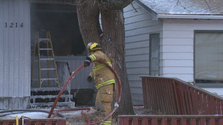 A Regina firefighters helps battle a stubborn house fire Thursday morning on the 1200 block of King Street. 