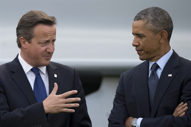 U.S. President Barack Obama speaks with British Prime Minister David Cameron during a flypast at the NATO summit at the Celtic Manor Resort in Newport, Wales in a Friday, Sept. 5, 2014 file photo.
