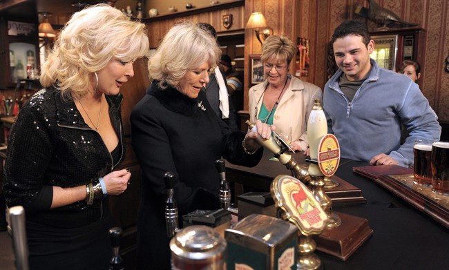 FILE - In this Thursday, Feb. 4, 2010 file photo, the Duchess of Cornwall, second left, pulls a pint of beer in the Rovers Return pub, as she meets actors Beverley Callard, left, who plays landlady Liz McDonald, Anne Kirkbride, second right, who plays Deirdre Barlow, second right, and Ryan Thomas, who plays Jason Grimshaw, during a visit to the the set of the British television soap opera 'Coronation Street', in Manchester, England.