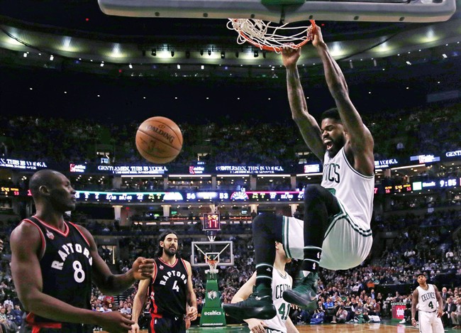 Boston Celtics forward Amir Johnson (90) hangs on the rim on a slam dunk against the Toronto Raptors during the second half of an NBA basketball game in Boston, Wednesday, March 23, 2016. The Celtics defeated the Raptors 91-79. (AP Photo/Charles Krupa).