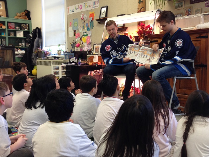 Manitoba Moose defenceman Josh Morrissey and goalie Eric Comrie read to students at Governor Semple School on Tuesday afternoon.