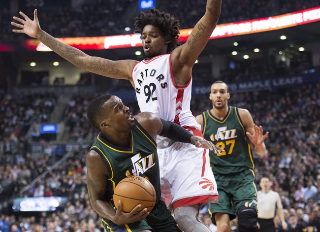Toronto Raptors centre Lucas Nogueira (92) defends against Utah Jazz guard Shelvin Mack (8) during first half NBA basketball action in Toronto on Wednesday, March 2, 2016. THE CANADIAN PRESS/Nathan Denette.