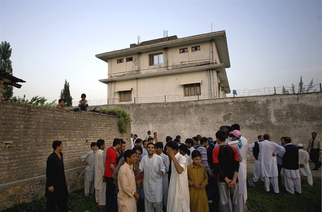 In this May 3, 2011, file photo, local residents gather outside a house in Abbottabad, Pakistan, where al-Qaida leader Osama bin Laden was killed in a raid. 