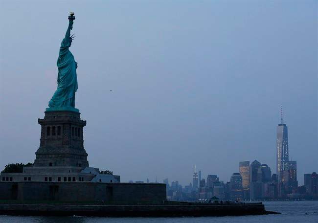 In this Tuesday, July 7, 2015, file photo, the Statue of Liberty stands in New York harbor with the New York City skyline in the background.
