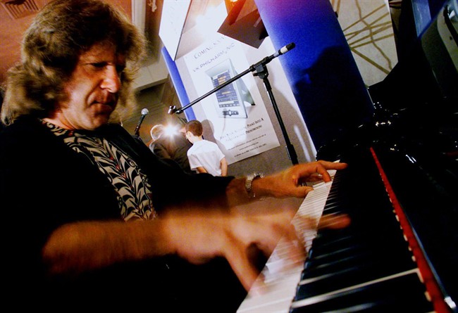 FILE - In this Aug. 12, 1999 file photo, musician Keith Emerson plays the new Van Koevering Interactive Piano, designed by electronic engineer Bob Moog, in Beverly Hills, Calif. Emerson, the keyboardist and founding member of the 1970s progressive rock group Emerson, Lake and Palmer, died Thursday, March 10, 2016, at home in Santa Monica, Calif. He was 71. 
