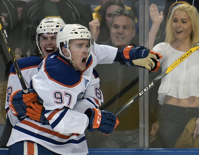 Edmonton Oilers defenseman Brandon Davidson, left, celebrates with center Connor McDavid (97) after McDavid scored in overtime of an NHL hockey game against the Buffalo Sabres, Tuesday, March 1, 2016, in Buffalo, N.Y. Edmonton won 2-1.