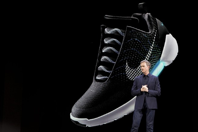 An image of the Nike HyperAdapt 1.0 is projected on a screen as Nike CEO Mark Parker speaks during a news conference, Wednesday, March 16, 2016, in New York. 