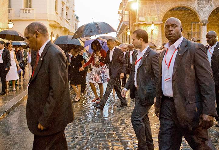 U.S. President Barack Obama walks in the rain with first lady Michelle Obama during a walking tour of Old Havana, Cuba, Sunday, March 20, 2016.