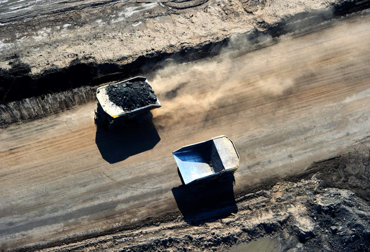 Huge Caterpillar 797 dump trucks working at the CNRL (Canadian Natural Resources Limited) Horizon oil sands mine near Fort McMurray, Alberta. They are the world's largest and carry 400 ton loads of oil sands ore.  The Canadian Press Images/Larry MacDougal.