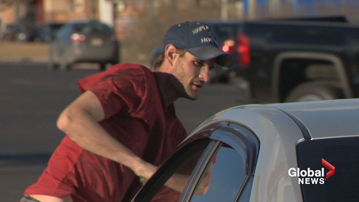 A 32-year-old who asked us to call him "Squeegee" washes window along northbound Macleod Trail and Glenmore Trail South, hoping to be rewarded with spare change.