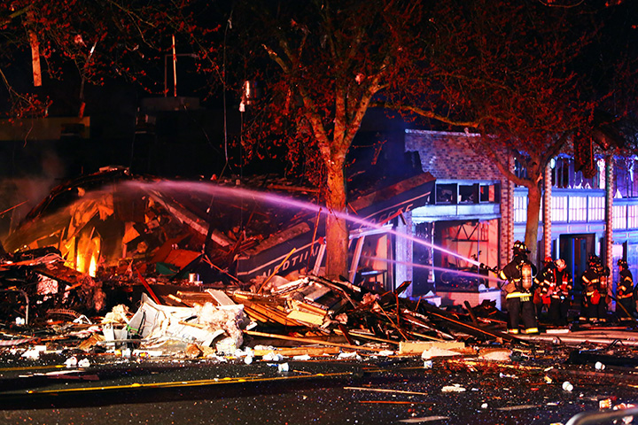 Seattle firefighters work to put out flames at the scene of a building explosion in Seattle’s Greenwood neighbourhood early Wednesday, March 9, 2016.