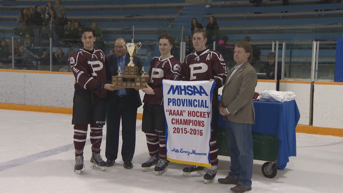 The St. Paul's Crusaders pose with the trophy and the championship banner following their victory in the AAAA Provincial Hockey final.