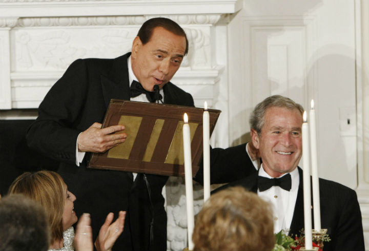 Prime Minister of Italy Silvio Berlusconi holds the top portion of the podium as he walks over to President George W. Bush to thank him during an Official Dinner in the State Dining Room Monday, Oct. 13, 2008. The podium came apart during Berlusconi’s remarks to the President.