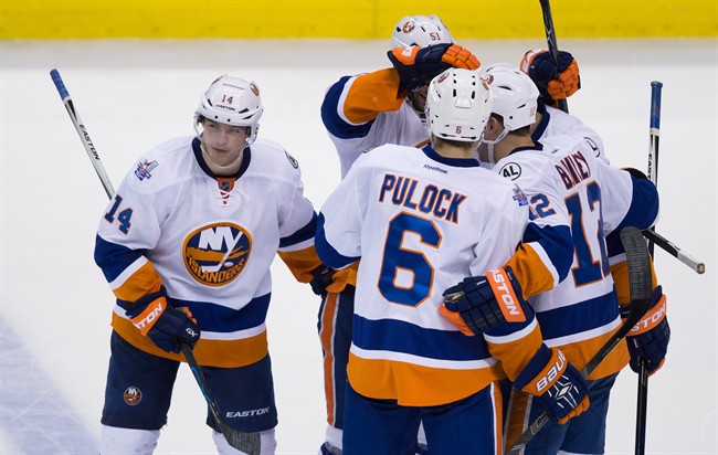 New York Islanders' Thomas Hickey, from left, Frans Nielsen, of Denmark, Ryan Pulock, Josh Bailey and Kyle Okposo celebrate Hickey's goal against the Vancouver Canucks during the third period of an NHL hockey game in Vancouver, B.C., on Tuesday March 1, 2016.