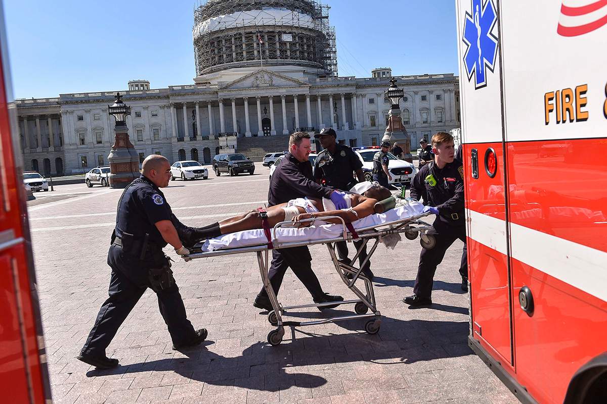 The suspect’s face was digitally altered by the Washington Post at the request of the Washington D.C. Fire and EMS Department. First responders transport the person believed to be the suspect in a shooting.