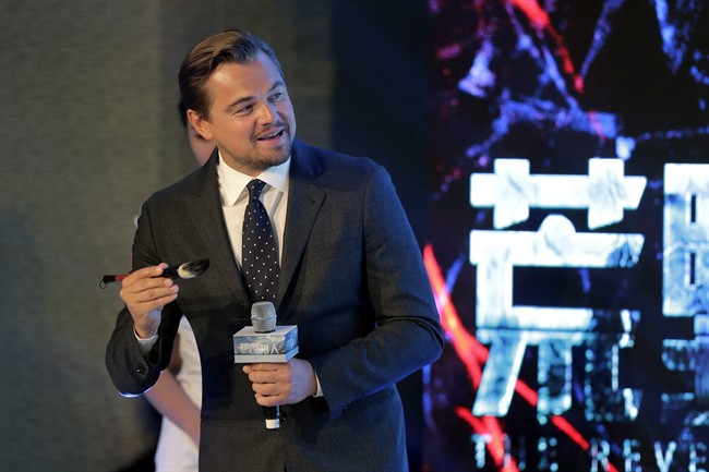 Actor Leonardo DiCaprio holds a Chinese writing brush as he prepares to write his name on stage during a news conference of the movie “The Revenant” at a hotel in Beijing, Sunday, March 20, 2016. 