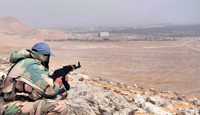In this photo released on Thursday, March 24, 2016, by the Syrian official news agency SANA, a Syrian government soldier takes his position on hill at the entrance of Palmyra, central Syria.  (File photo).