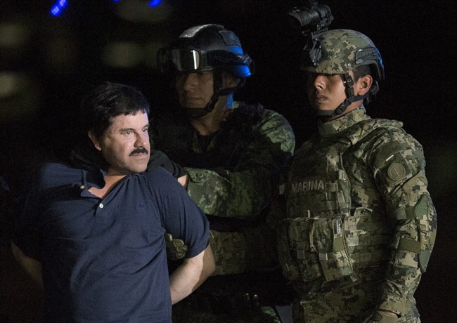In this Jan. 8, 2016, file photo, Mexican drug lord Joaquin "El Chapo" Guzman is escorted by army soldiers to a waiting helicopter, at a federal hangar in Mexico City.