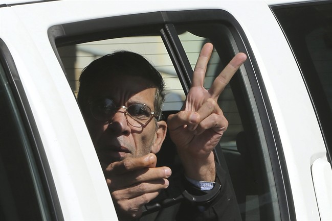 EgyptAir plane hijacking suspect Seif Eddin Mustafa flashes the victory sign as he leaves a court in a police car after a remand hearing as authorities investigate him on charges including hijacking, illegal possession of explosives and abduction in the Cypriot coastal town of Larnaca Wednesday, March 30, 2016. Mustafa described as "psychologically unstable" hijacked a flight Tuesday from Egypt to Cyprus and threatened to blow it up. His explosives turned out to be fake, and he surrendered with all passengers released unharmed after a bizarre six-hour standoff.