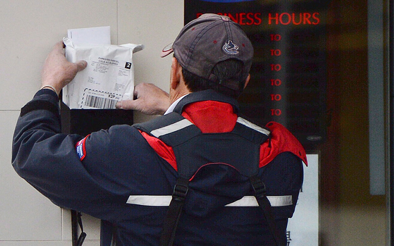 A mail carrier delivers mail in Ottawa, on Dec.11, 2013. 