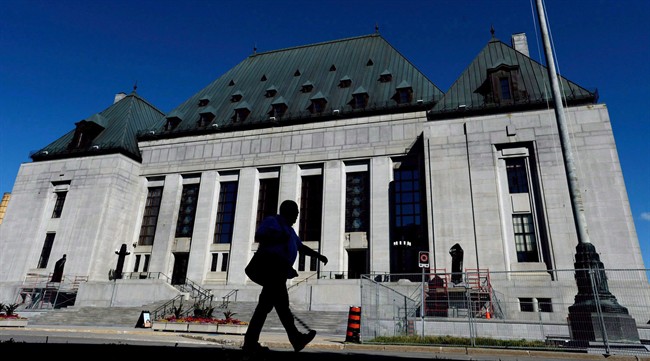 A pedestrian walks past the Supreme Court of Canada in Ottawa on Thursday, July 23, 2015. 