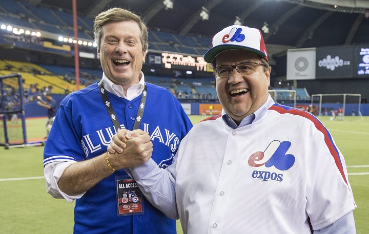Montreal Mayor Denis Coderre, right, shares a laugh with Toronto counterpart John Tory prior to the Blue Jays facing the Boston Red Sox in a spring training baseball game Saturday, April 2, 2016 in Montreal.
