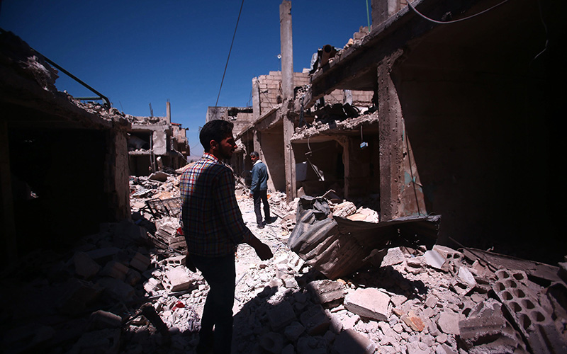 People inspect damaged buildings that were targeted by airstrikes in Deir al-Asafir district, southeast of Damascus, Syria, 04 April 2016. 