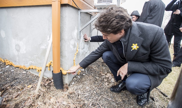 Prime Minister Justin Trudeau looks at the foundation of a house weakened by pyrite, Wednesday, April 6, 2016 in Trois-Rivieres, Que.