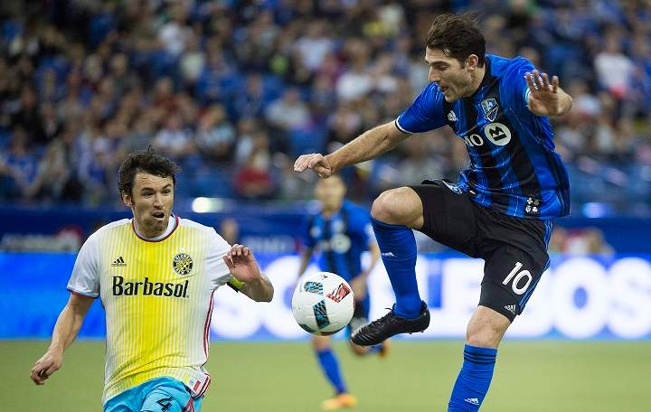 Montreal Impact's Ignacio Piatti, right, challenges Columbus Crew SC's Michael Parkhurst (4) during first half MLS soccer action in Montreal, Saturday, April 9, 2016.