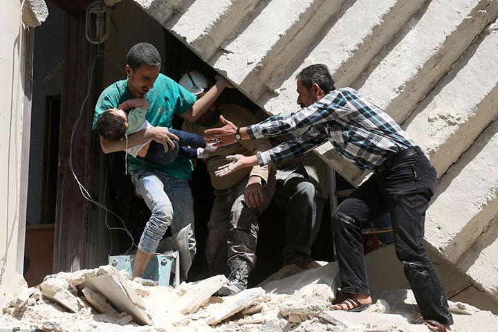 Syrians evacuate a toddler from a destroyed building following a reported air strike on the rebel-held neighbourhood of al-Kalasa in the northern Syrian city of Aleppo, on April 28, 2016. The civilian death toll of the US-led coalition airstrikes has been greatly under-reported, critics say.