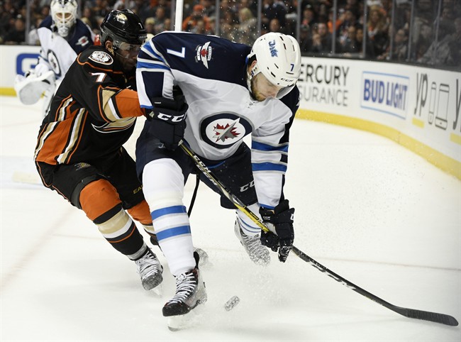 Winnipeg Jets defenceman Ben Chiarot, right, moves the puck while under pressure drom Anaheim Ducks left wing Andrew Cogliano, left, during the second period of an NHL hockey game in Anaheim, Calif., Tuesday, April 5, 2016.