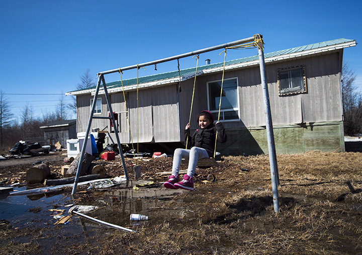 Eight-year-old Shakira Koostachin plays on a swing in the northern Ontario First Nations reserve in Attawapiskat, Ont., on Tuesday, April 19, 2016. 