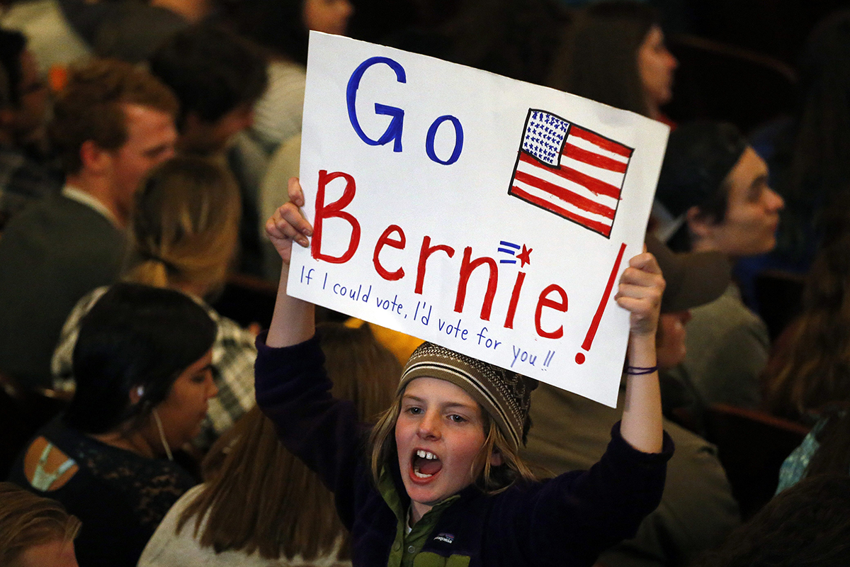 Local 3rd grader Marlow Mittelstaedt holds a sign and cheers while waiting for the arrival of Democratic presidential candidate Sen. Bernie Sanders before a campaign rally in Laramie, Wyo., Tuesday, April 5, 2016. 