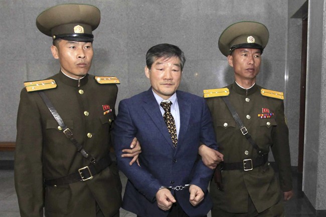 Kim Dong Chul, center, a U.S. citizen detained in North Korea, is escorted to his trial Friday, April 29, 2016, in Pyongyang, North Korea. A North Korean court has sentenced an ethnic Korean U.S. citizen to 10 years in prison for what it called acts of espionage. 
