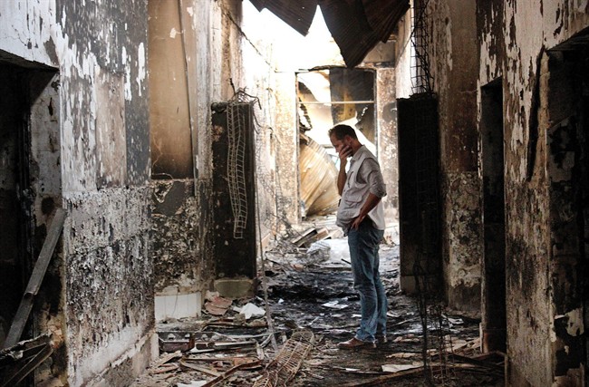 In this Oct. 16, 2015, file photo, an employee of Doctors Without Borders walks inside the charred remains of the organization's hospital after it was hit by a U.S. airstrike in Kunduz, Afghanistan.