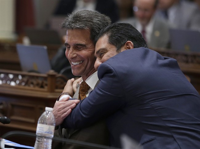 State Sen. Mark Leno, D-San Francisco, left, one of the authors of a bill to raise California's minimum wage, is hugged by Sen. Ben Hueso, D-San Diego, as the Senate voted on the bill, Thursday, March 31, 2016, in Sacramento, Calif. (AP Photo/Rich Pedroncelli).