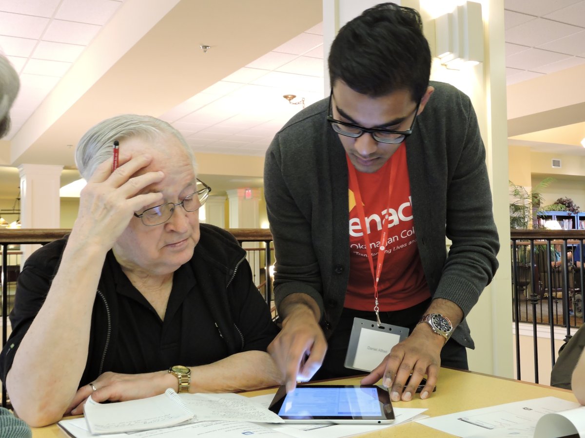 Okanagan College student and Silver Surfers co-founder Daniel Alfred explains how to use an iPad to a resident of Missionwood Retirement Resort.