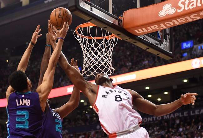 Charlotte Hornets' Al Jefferson, Jeremy Lamb (3) and Toronto Raptors' Bismack Biyombo (8) battle for a rebound during first half NBA basketball action in Toronto on Tuesday, April 5, 2016. THE CANADIAN PRESS/Frank Gunn.